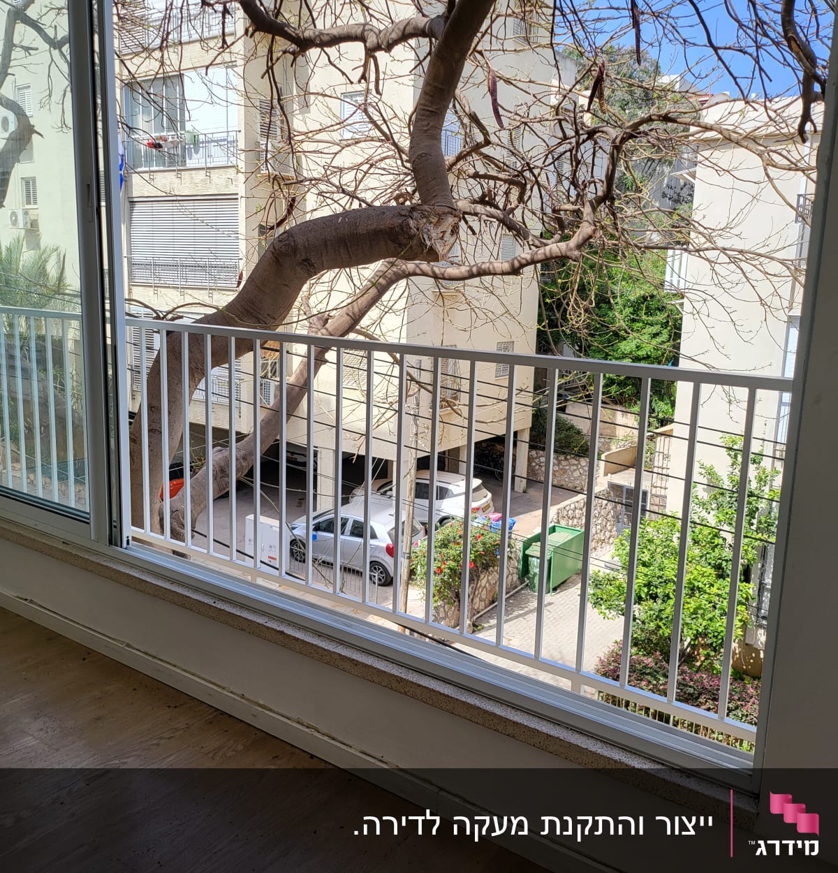 חלון עם מסגרת מתכת לבנה ועץ ברקע